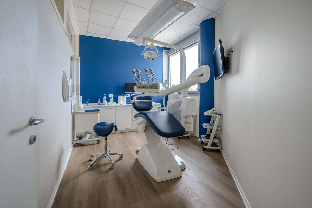 Una sala di cura con riunito e parete blu